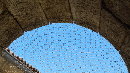 Filet anti-pigeons posé sur les ouvertures d'un clocher corse